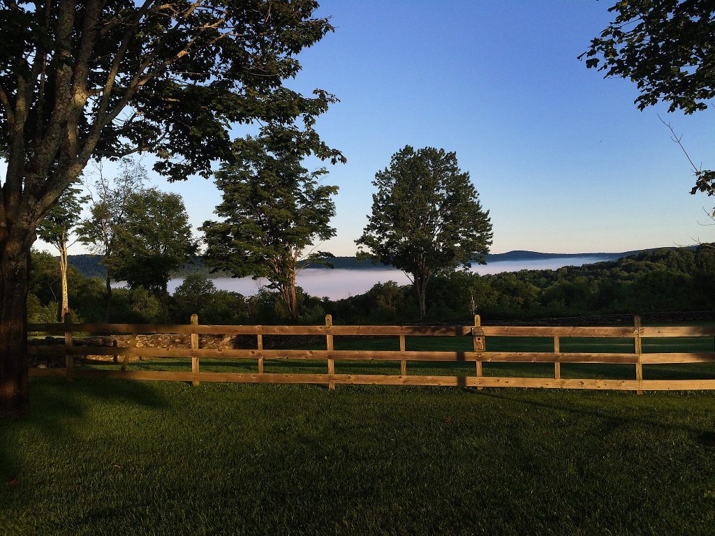 View of misty hills and fence